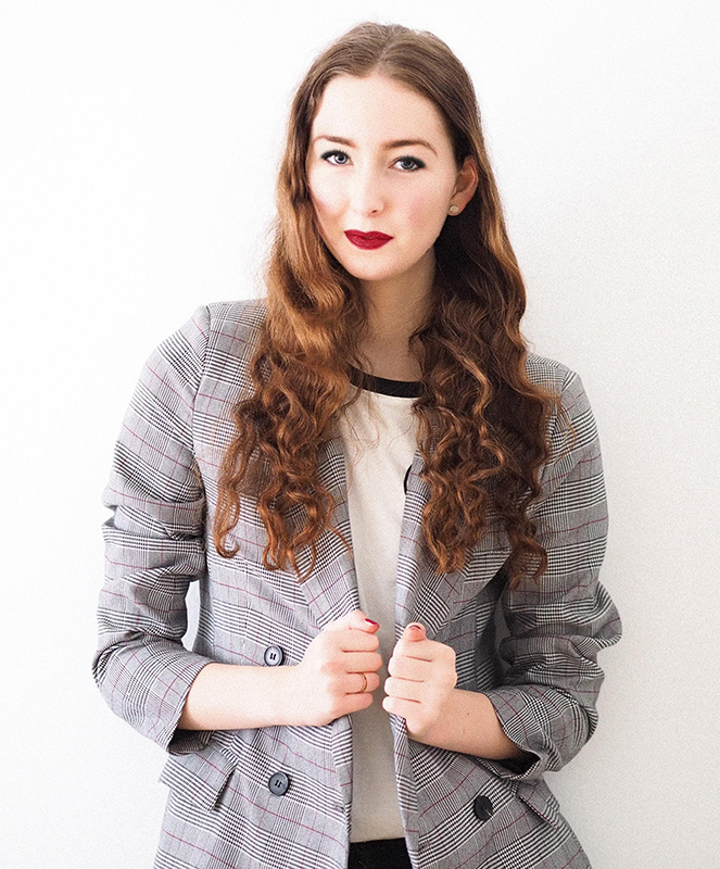 Woman wearing red lipstick and a grey oversized blazer by Laura Chouette